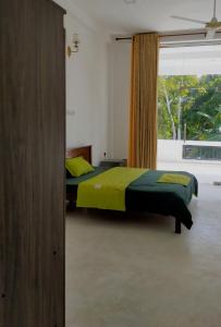 a bedroom with two beds and a large window at Mangroven River View Hotel in Bentota
