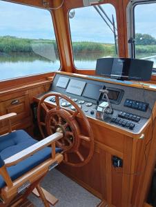 a dashboard of a boat with a steering wheel at Deluxe romantic boat in Hoogeveen