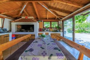 a dining room with a table and a kitchen at Apartments Milorad M in Lopar