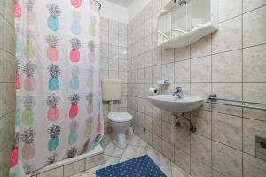 a bathroom with a toilet and a shower curtain at Apartments Milorad M in Lopar +88 photos