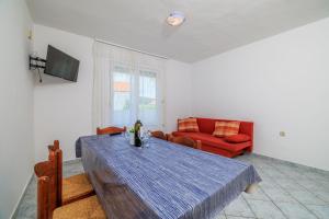 a living room with a table and a red couch at Apartments Milorad M in Lopar