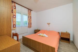 a bedroom with a bed with two stuffed animals on it at Apartments Milorad M in Lopar