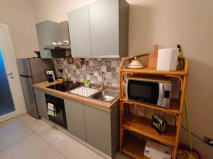 a small kitchen with a sink and a microwave at SaggioHome Holiday House in Naples