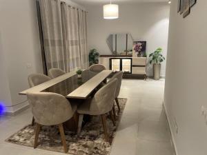 Un comedor con mesa y sillas de madera. en Chalet for rent for families of 5-8, en El Alamein