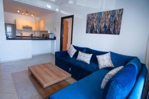 a blue couch in a living room with a table at La perle bleue de Beralmar Asilah in Oulad Akkou