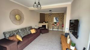 Una sala de estar con un sofá y una chimenea. en Chalé da Serra, en Santo da Serra