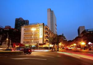 a city street at night with cars driving down the street at Yanjiang East Garden Inn in Guangzhou