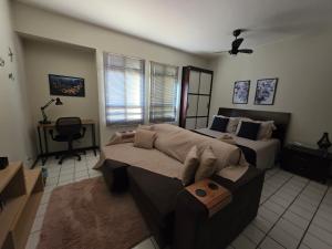 a bedroom with a couch and a bed and a desk at Studio no Sudoeste in Brasilia