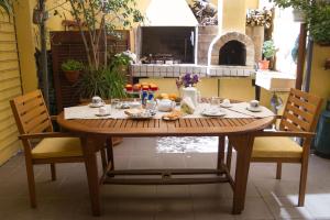 einen Holztisch mit Essen darauf mit zwei Stühlen in der Unterkunft Pimpioxelli in Quartucciu