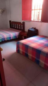 a room with two beds and a suitcase at Refugio olgamar, Cabaña con kiosco cerca al mar in Moñitos