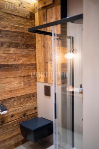 baño con aseo y pared de madera en Aparthotel ZATOR Natural 56 jacuzzi, en Zator 55 fotos más