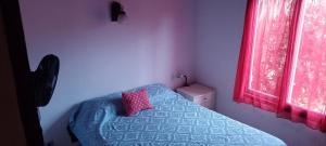a bedroom with a bed with a pillow and a window at Casa Los colibrí in Frente Mar +23 photos