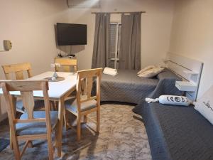 a room with a desk and a room with two beds at El Refugio del Calden in Toay