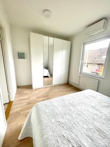 um quarto com uma cama branca e um espelho em Nya 1or 2or i centrala Halmstad em Halmstad