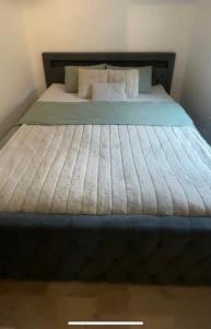 um quarto com uma cama grande com lençóis e almofadas azuis em Nya 1or 2or i centrala Halmstad em Halmstad