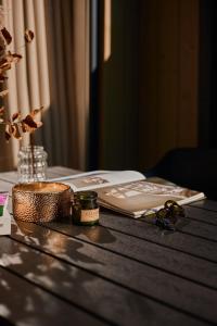 a table with a book and a candle on it at Domki Premium Nautica blisko plaży in Rewal