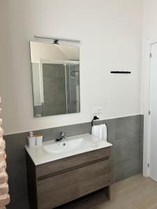 ein Badezimmer mit Waschbecken und Spiegel in der Unterkunft Apartamentos Puerta los Castañares B in Constantina
