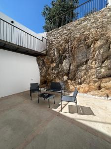 eine Gruppe von Bänken, die neben einer Steinmauer sitzen in der Unterkunft Apartamentos Puerta los Castañares B in Constantina