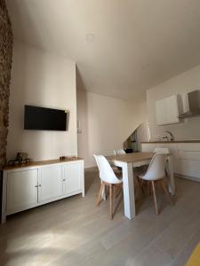 ein Esszimmer mit Tisch und Stühlen und einem Fernseher in der Unterkunft Apartamentos Puerta los Castañares B in Constantina