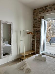 ein Schlafzimmer mit einem Spiegel und einem Bett mit Handtüchern in der Unterkunft Apartamentos Puerta los Castañares B in Constantina