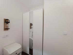 a white bathroom with a toilet and a mirror at Casamor in Tollo
