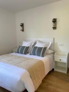 a large white bed with two pillows on it at Casamor in Tollo