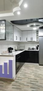 kuchnia z białymi szafkami i fioletowym blatem w obiekcie TEMO'S APARTAMENT IN KUTAISI w Kutaisi