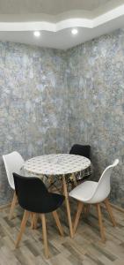 stół i krzesła w pokoju z kamienną ścianą w obiekcie TEMO'S APARTAMENT IN KUTAISI w Kutaisi +9 zdjęć