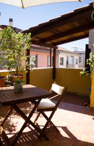 een houten tafel en een stoel op een patio bij Pimpioxelli in Quartucciu