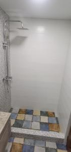 łazienka z prysznicem i kolorową podłogą z płytek w obiekcie TEMO'S APARTAMENT IN KUTAISI w Kutaisi