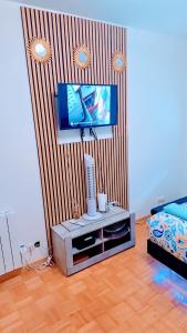 a living room with a television and a bed at Des studios idéaux pour les professionnels tramway devant l'immeuble in La Courneuve