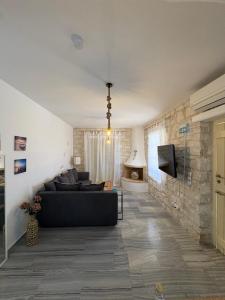 a living room with a black couch and a stone wall at Casa Maximos in Santa Maria