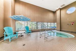 a room with a pool with chairs and a table and an umbrella at 17th Avenue Paranomas Escape in Calgary