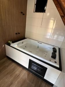 a white bath tub in a bathroom with a window at CHALÉS VILA RICA - Bar do Ricardo in Ouro Preto +73 photos