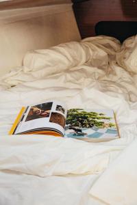 un libro sentado en la parte superior de una cama en Seaside Retreat with Postcard Views, en Cascais