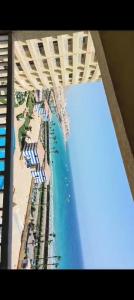 a view of a beach with umbrellas and the ocean at Pyramids Porto Sokhna Families Only in Ain Sokhna