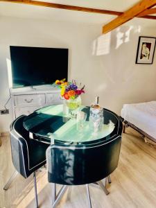 Wood Chalet 1 Monaco Forest La Turbie - Sleeps 4 people في لا توربي: طاولة زجاجية عليها إناء من الزهور