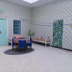 a room with a table and chairs and a bed at Bouchama's Arabesque house in Mahdia