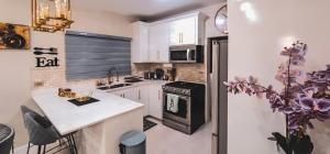 a kitchen with white cabinets and a black stove top oven at Modern Island Escape -Pool-Gym & Patio in Ocho Rios