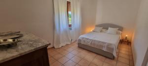 a bedroom with a bed with white sheets and a window at la dimora di Fonte Vecchia in San Pio delle Camere