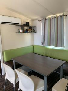 ein Esszimmer mit einem Tisch und weißen Stühlen in der Unterkunft Casa prefabricada in El Casar de Escalona