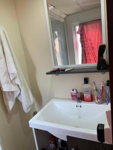 ein Badezimmer mit einem weißen Waschbecken und einem Spiegel in der Unterkunft Casa prefabricada in El Casar de Escalona + 3 Fotos