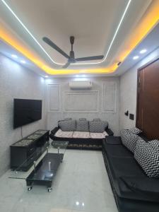 a living room with a couch and a flat screen tv at FIAA Hospitality 3BHK 2 FLATS in New Delhi