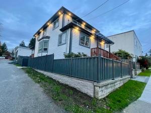 a house with a fence and lights on it at Budget Friendly 2 Bedroom Suite - Save on Weekly and Monthly Stays! in New Westminster