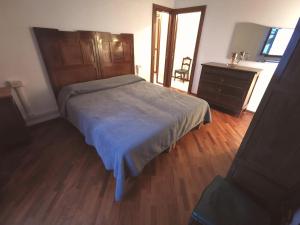 a bedroom with a large bed and a dresser at Spacious Historic Apartment F1 in Gravedona