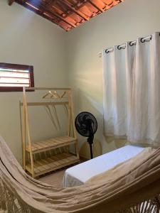 a hammock in a bedroom with a bed and a window at Casa em Praia de Flecheiras in Trairi