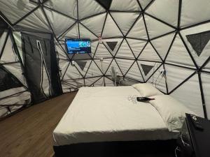 une chambre avec un lit dans une tente avec une télévision dans l'établissement Finca turística Villa Carolina, à Sabaletas