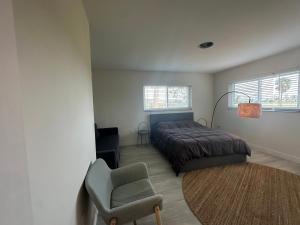 a bedroom with a bed and a chair and window at Beautiful 2-bedroom, 2-bathroom In Rotonda West in Rotonda West