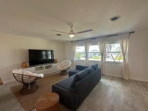 a living room with a blue couch and a tv at Beautiful 2-bedroom, 2-bathroom In Rotonda West in Rotonda West