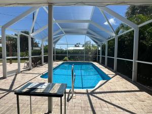 a swimming pool under a pavilion with a table and a bench at Charming 3-bedroom House In Delightful Englewood in Englewood
